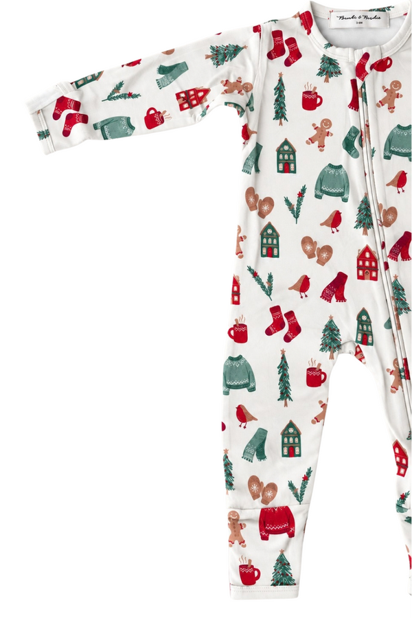 A baby long-sleeve footless sleep sack with a festive Christmas print on a white background. The pattern features red and green holiday motifs including stockings, gingerbread men, Christmas trees, hot cocoa mugs, and small houses.