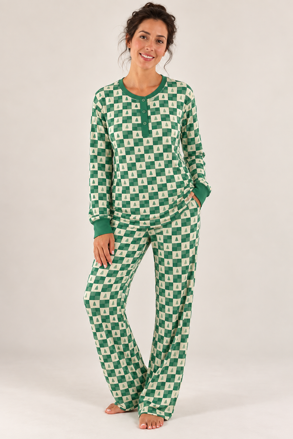 A woman modeling a matching long-sleeve pajama set with a green and white pattern, standing against a plain white studio background.