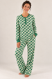 A woman modeling a matching long-sleeve pajama set with a green and white pattern, standing against a plain white studio background.